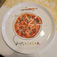 "empty plate with drawing of a pizza and witty geometric calculation, refer to caption"