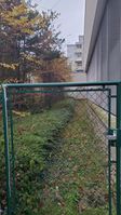 "gate with path leading to service building behind it"