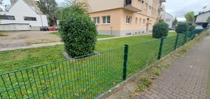 "paved footway to the right; fence with lawn and other footway behind"