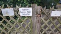 "wooden gate with sign forbidding public access"