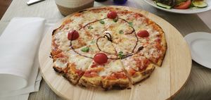 "delicious-looking Pinsa Margherita with cherry tomatoes and some basil leaves" 