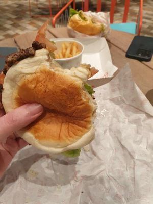 A photo of my hand holding my half-eaten burger